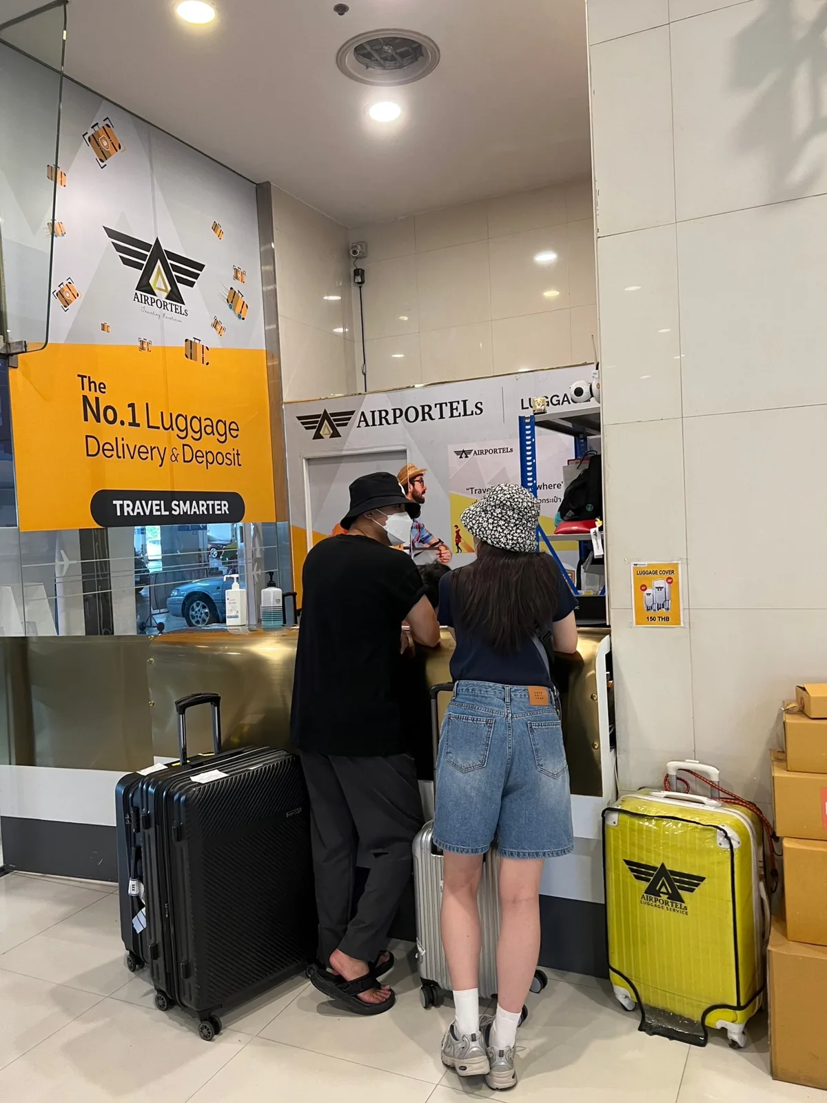Travellers with wheeled bags at the AIRPORTELs counter inside Terminal 21 Asok