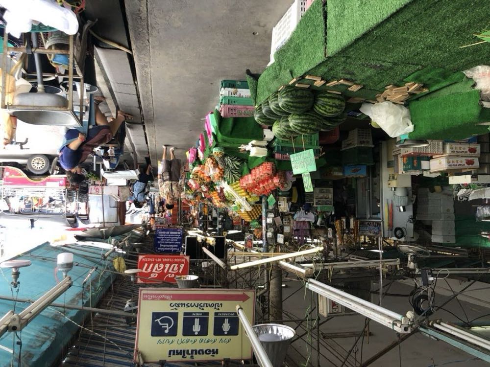 Train passing through Maeklong Railway Market stalls