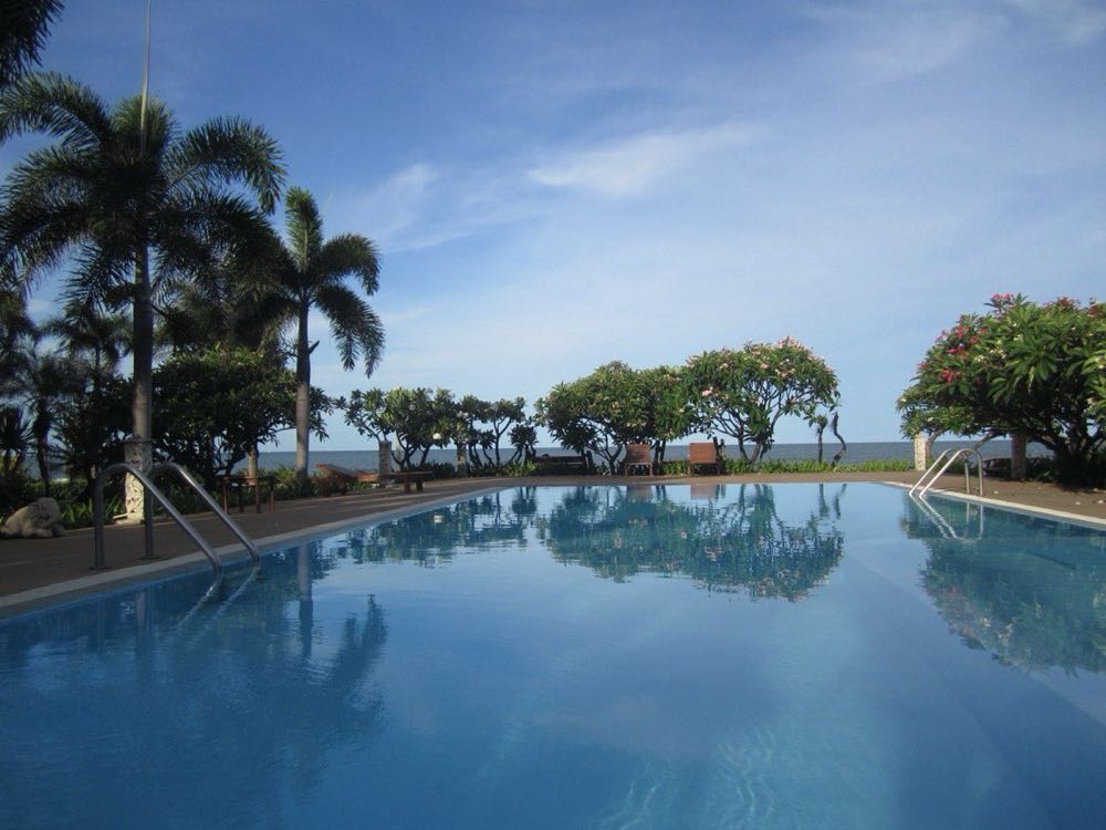Seafront resort pool with frangipani on the Pran Buri coast